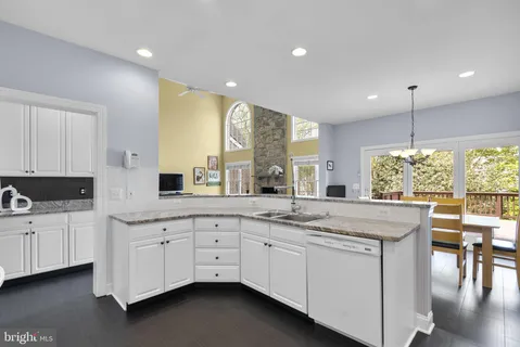 a kitchen with stainless steel appliances granite countertop a sink and cabinets with wooden floor