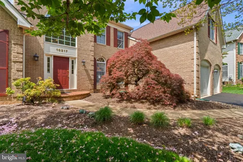 a front view of a house with yard and green space