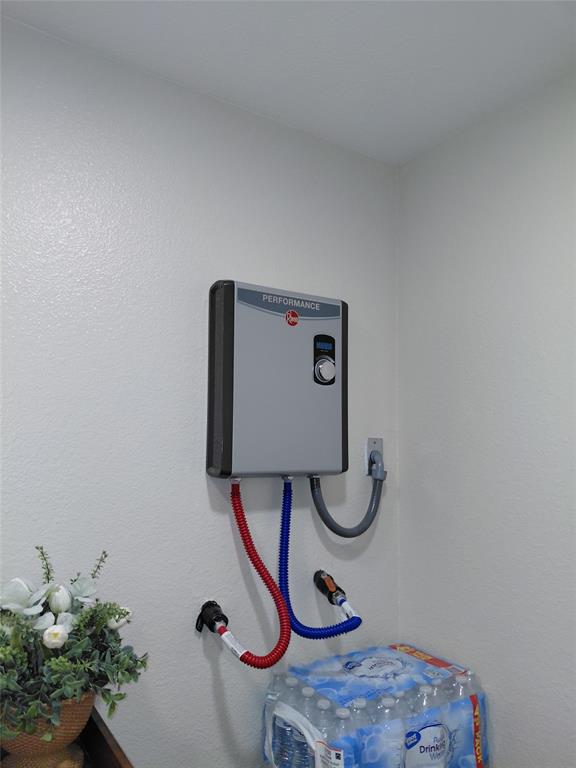 636 Clearfield Road Dallas, TX 75217 - Photo 7 of 10 Wall-mounted tankless water heater with visible controls and connected hoses