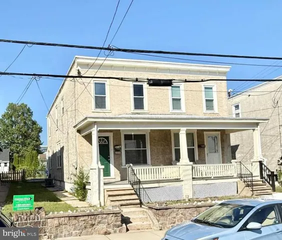 a view of a house with a small yard and sitting area