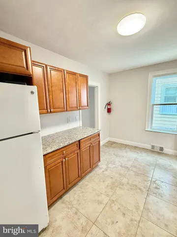 a kitchen with granite countertop a refrigerator and a sink