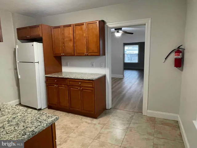 a kitchen with granite countertop a refrigerator and a stove top oven