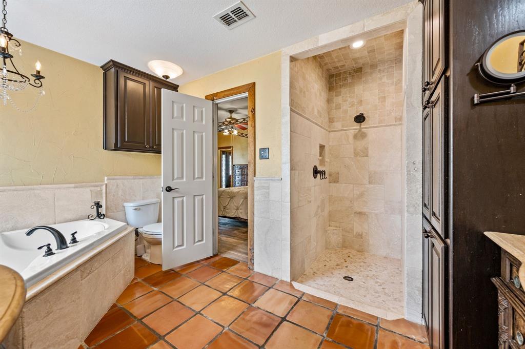 2141 Old Denton Road Decatur, TX 76234 - Photo 20 of 40 Primary bathroom with walk-in shower with natural stone-finish tiling