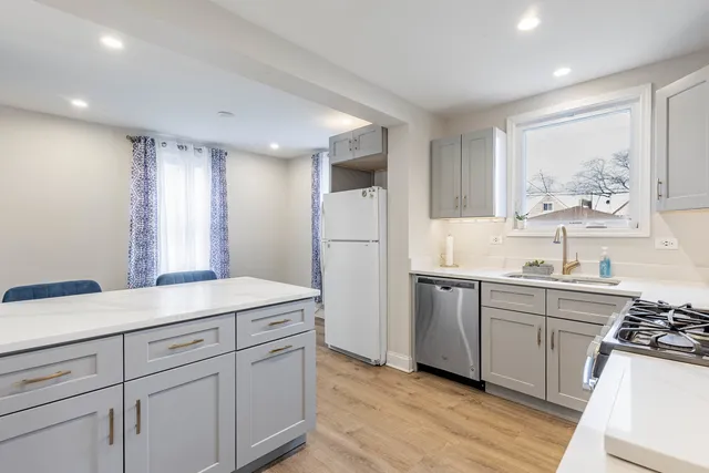a kitchen with white cabinets and white appliances