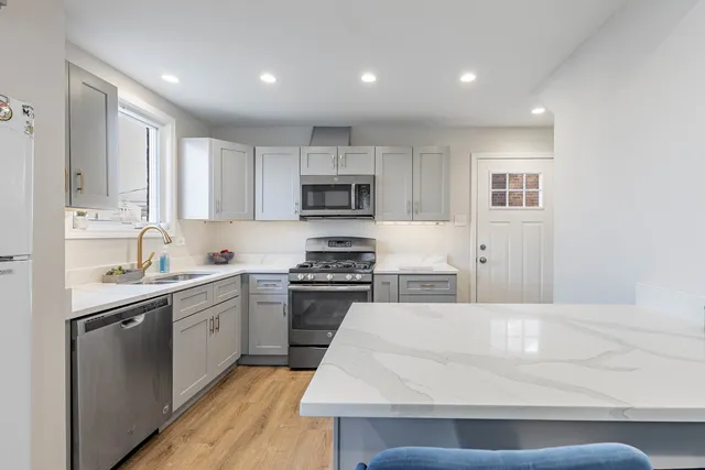 a kitchen with kitchen island white cabinets appliances and sink