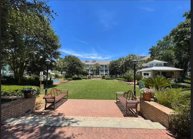 a view of a garden with lawn chairs under an umbrella