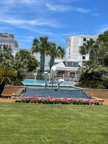 a view of swimming pool with lawn chairs and large trees