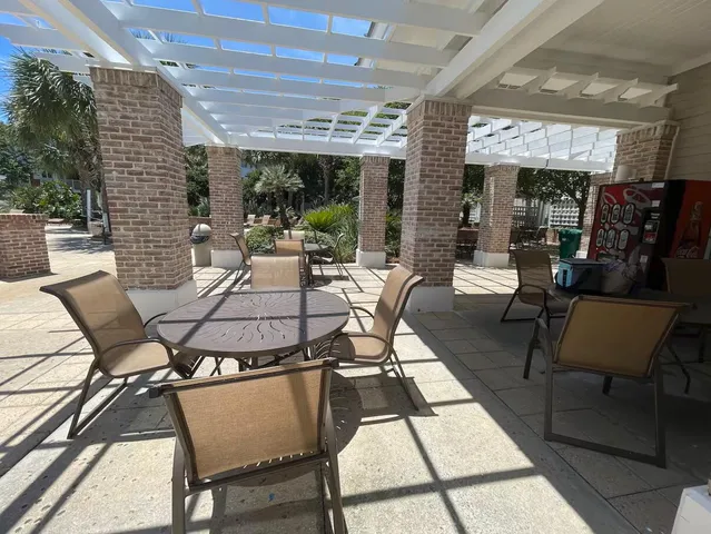 a view of a patio with a dining table and chairs with wooden floor