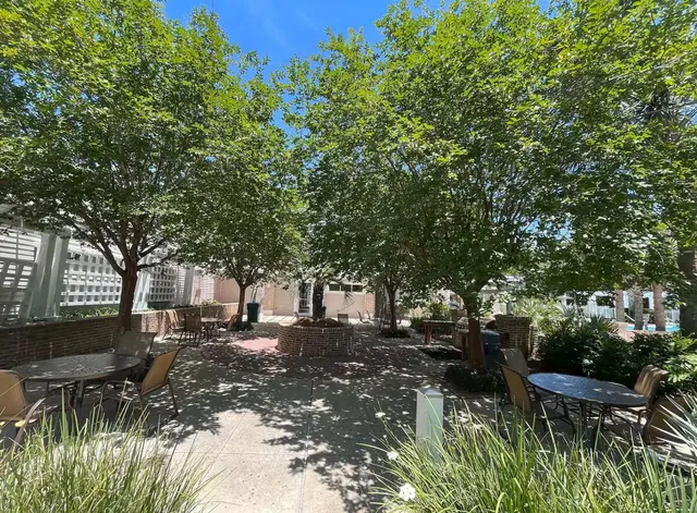 a view of backyard with table and chairs and potted plants