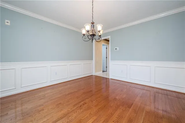 a view of a room with wooden floor and chandelier