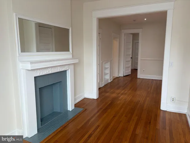 a view of a livingroom with wooden floor and a fireplace