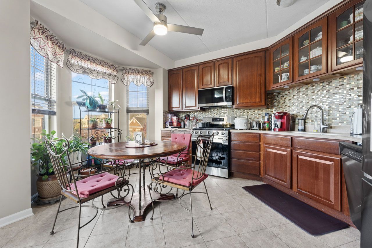 511 Prestwick Lane, Unit 302 Wheeling, IL 60090 - Photo 8 of 24 a kitchen with a stove a sink a dining table and chairs