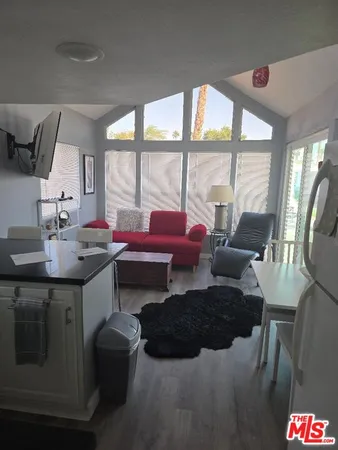 a living room with furniture and a floor to ceiling window