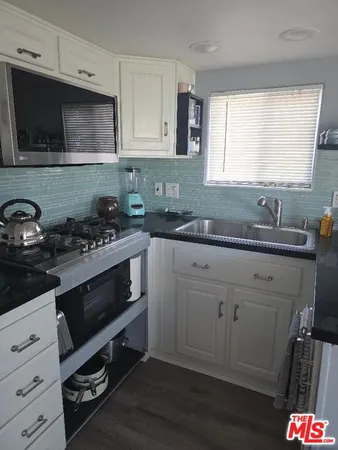 a kitchen with stainless steel appliances a sink a stove a microwave and cabinets