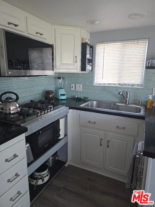 84136 Ave 44, Unit 372 Indio, CA 92203 - Photo 5 of 16 a kitchen with stainless steel appliances a sink a stove a microwave and cabinets