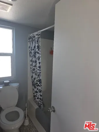 a bathroom with a toilet and a shower curtain