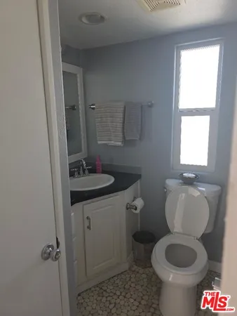 a bathroom with a granite countertop toilet sink and mirror