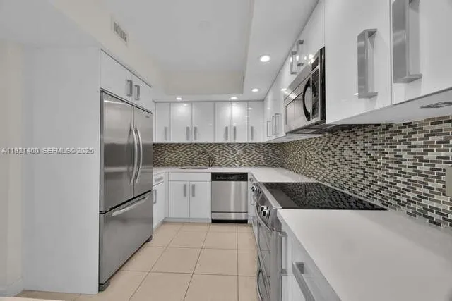 a kitchen with stainless steel appliances granite countertop a stove a microwave and a refrigerator