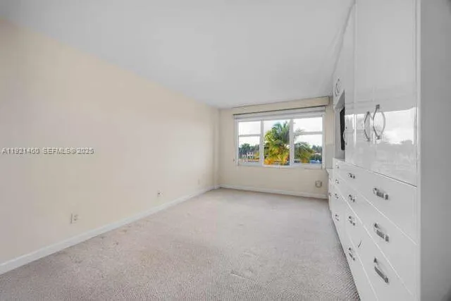 a view of an empty room with cabinet and flat screen tv