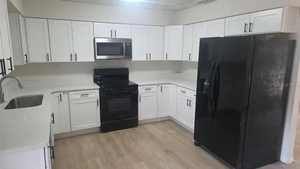 a kitchen with a refrigerator and a stove