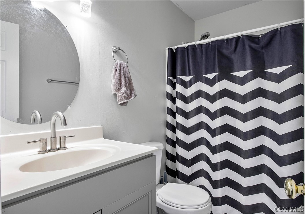 8911 Midway Road Henrico, VA 23229 - Photo 20 of 30 a bathroom with a sink a toilet and a mirror
