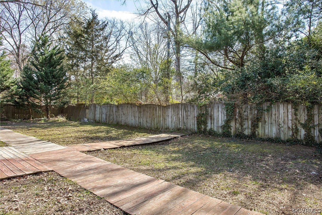 8911 Midway Road Henrico, VA 23229 - Photo 28 of 30 a view of a backyard with large trees and wooden fence