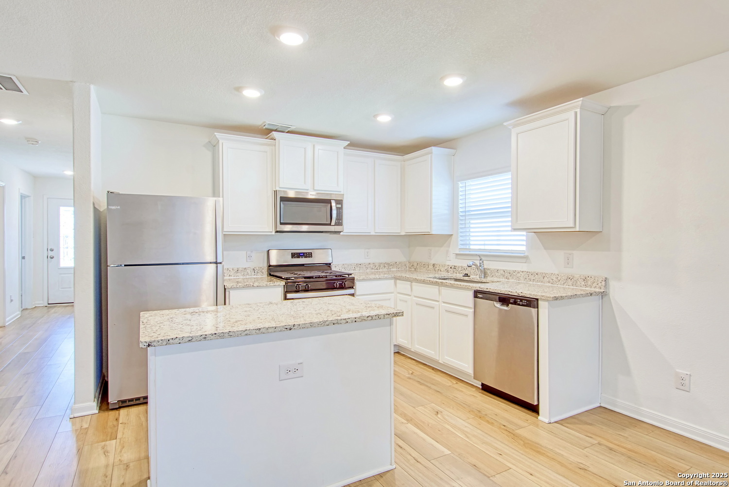 10939 Delight Grove Converse, TX 78109 - Photo 5 of 12 a kitchen with granite countertop white cabinets and stainless steel appliances