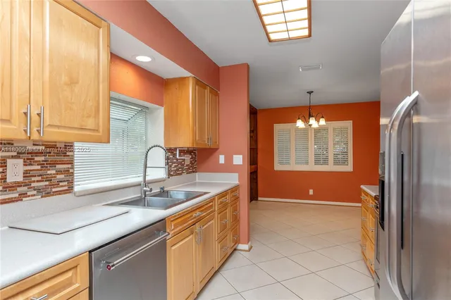 a kitchen with stainless steel appliances granite countertop a sink and a refrigerator