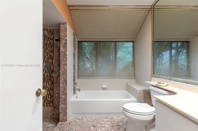 a bathroom with a granite countertop toilet and a sink