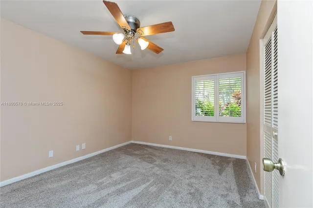 an empty room with closet and fan