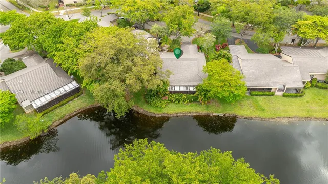 an aerial view of residential houses with outdoor space and trees