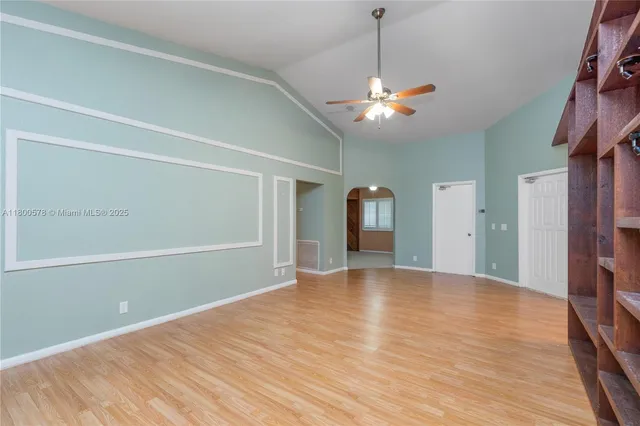 a view of an empty room with window and wooden floor