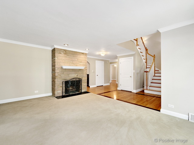 908 Ranch Road Wheaton, IL 60187 - Photo 4 of 25 a view of an empty room with fireplace and wooden floor