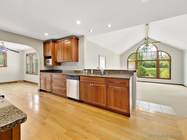908 Ranch Road Wheaton, IL 60187 - Photo 7 of 25 a kitchen with stainless steel appliances granite countertop a stove a sink and a microwave