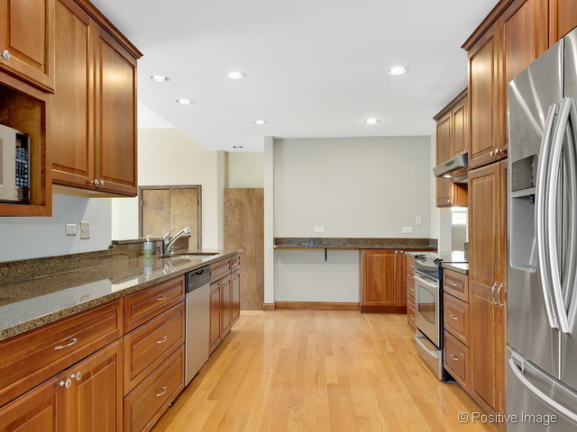 908 Ranch Road Wheaton, IL 60187 - Photo 8 of 25 a kitchen with stainless steel appliances granite countertop a refrigerator a sink and wooden cabinets