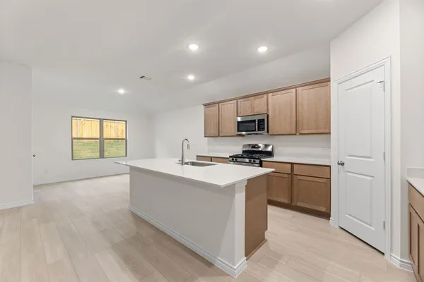 a kitchen with cabinets stainless steel appliances and a sink