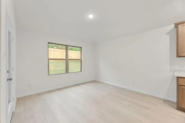 a view of kitchen with kitchen island a sink wooden floor and a refrigerator