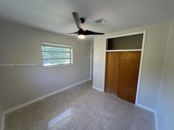 an empty room with fan and windows