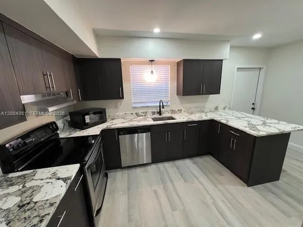 a kitchen with a sink a stove a refrigerator and cabinets