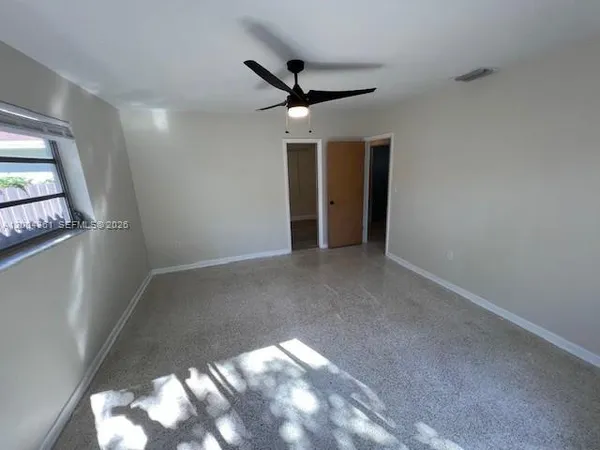 a view of a livingroom with a ceiling fan and window