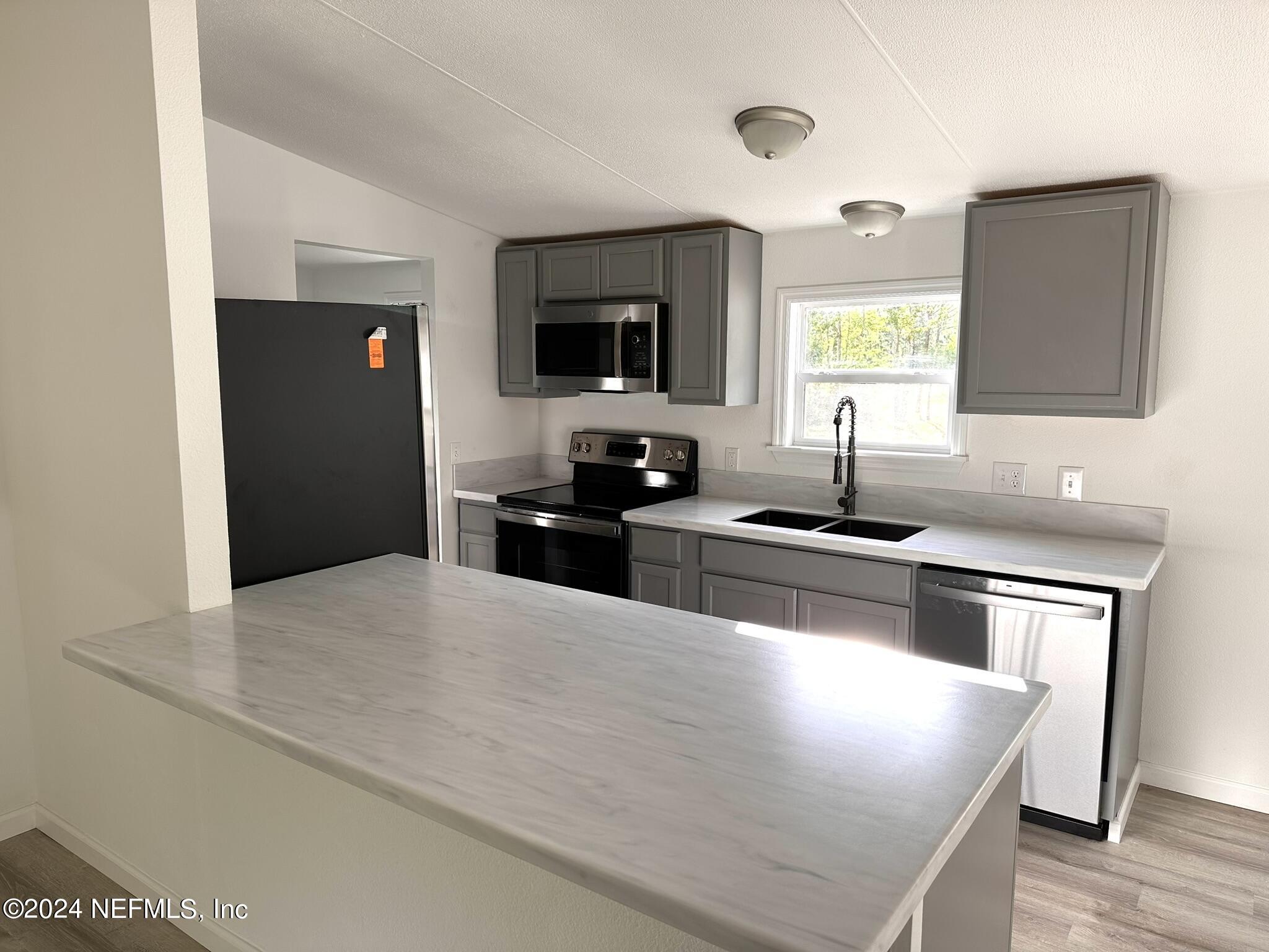 96757 Blackrock Road Yulee, FL 32097 - Photo 4 of 21 a kitchen with stainless steel appliances granite countertop a sink and a stove