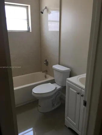 a white toilet sitting next to a bath tub