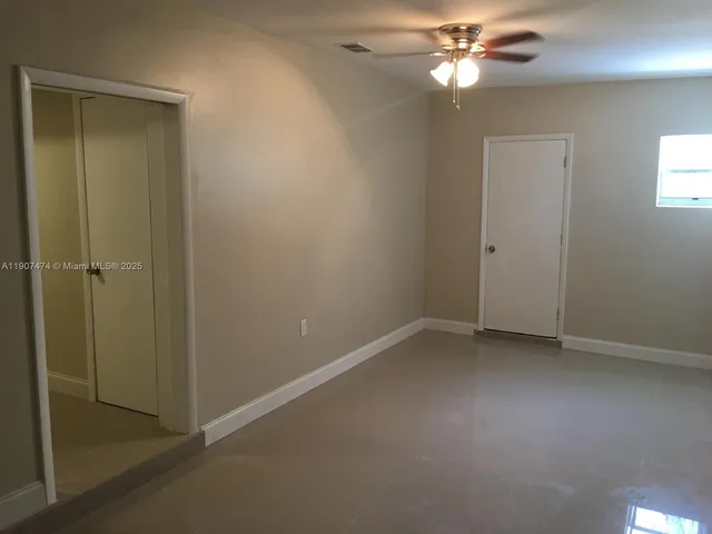 an empty room with closet and a chandelier fan