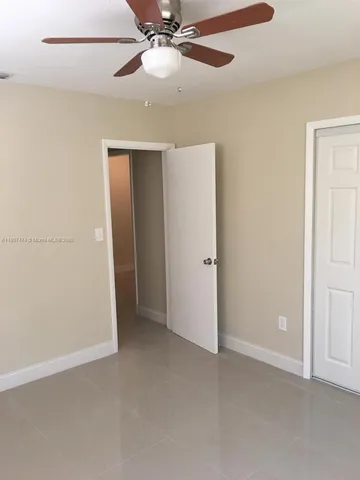 an empty room with closet and a chandelier fan