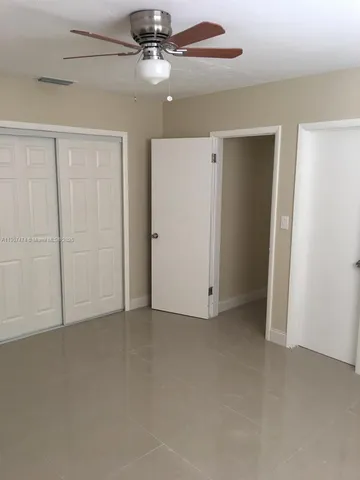 an empty room with chandelier fan