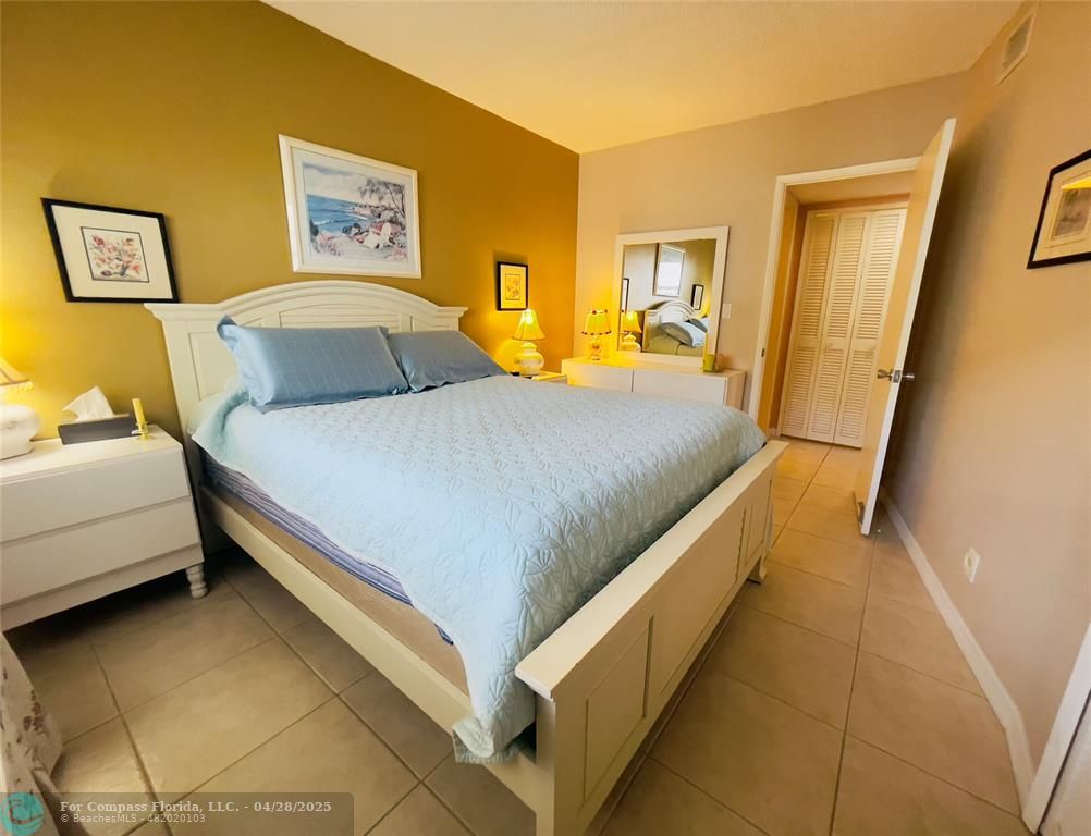 651 Pine Drive, Unit 207 Pompano Beach, FL 33060 - Photo 16 of 18 a bedroom with a bed and a lamp
