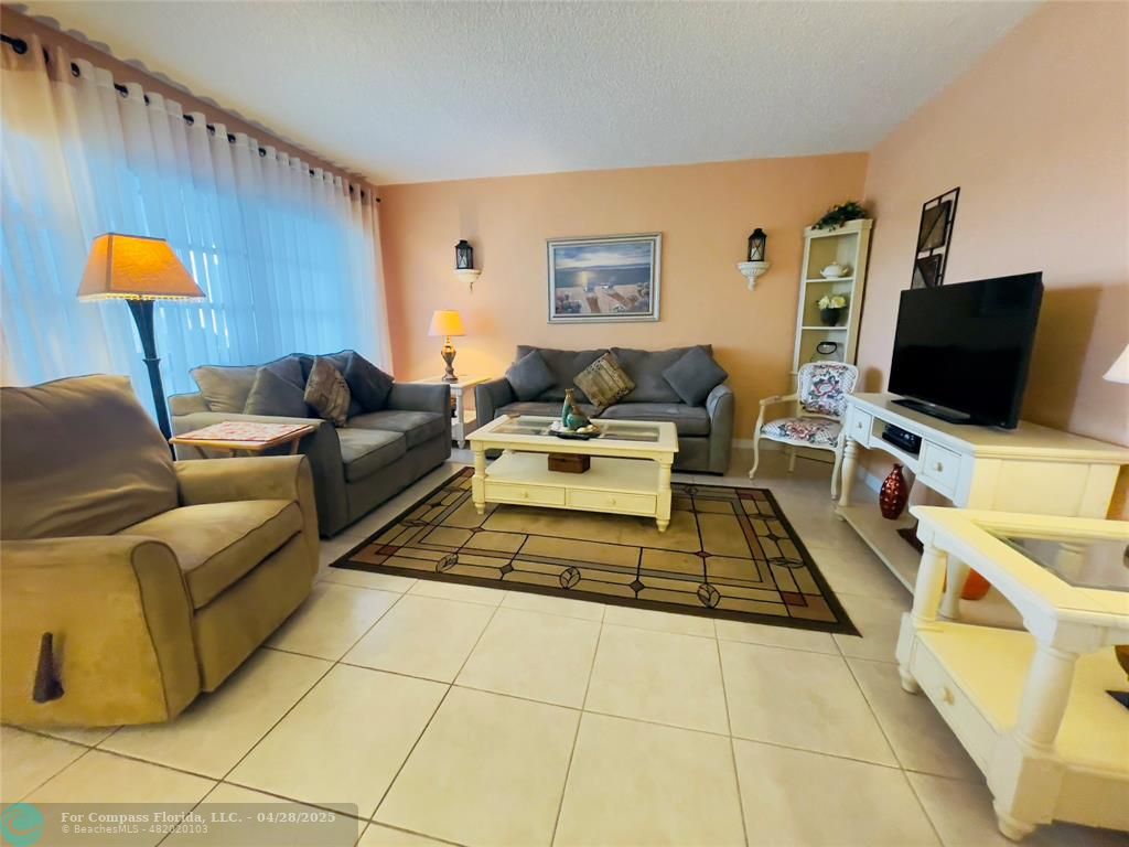 651 Pine Drive, Unit 207 Pompano Beach, FL 33060 - Photo 17 of 18 a living room with furniture and a flat screen tv