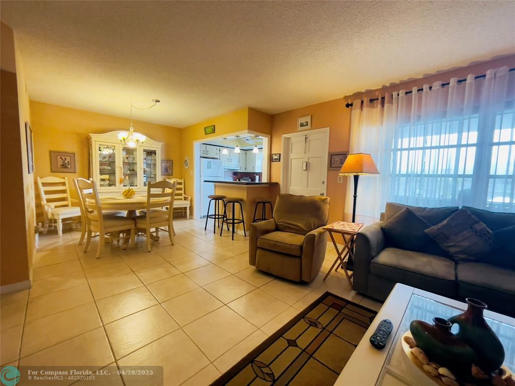651 Pine Drive, Unit 207 Pompano Beach, FL 33060 - Photo 18 of 18 a living room with furniture and a chandelier