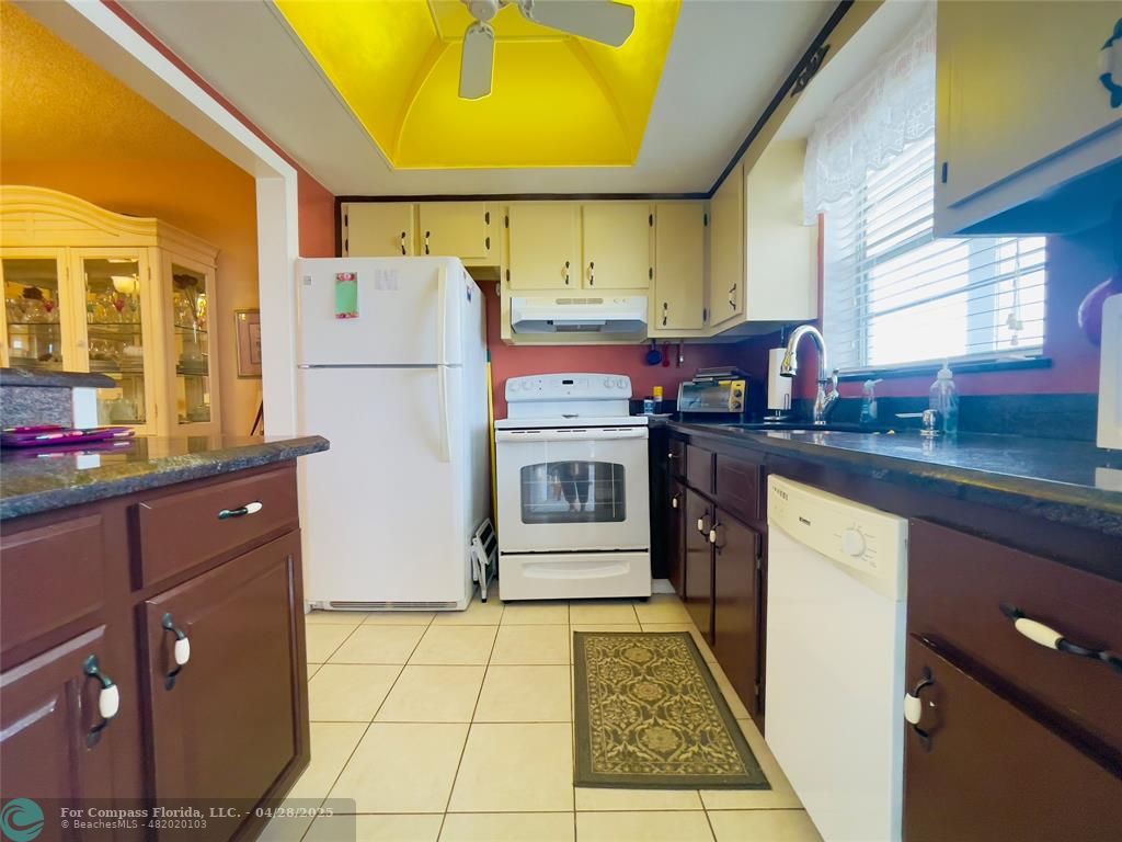 651 Pine Drive, Unit 207 Pompano Beach, FL 33060 - Photo 5 of 18 a kitchen with stainless steel appliances granite countertop a stove a sink and a refrigerator