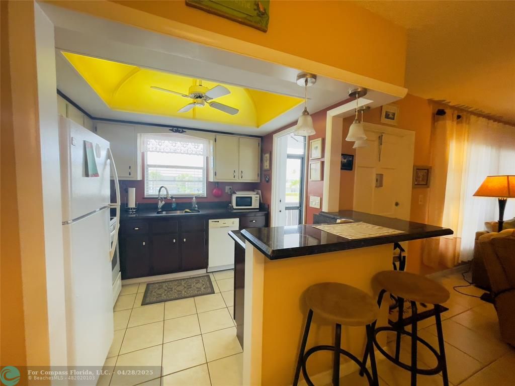651 Pine Drive, Unit 207 Pompano Beach, FL 33060 - Photo 6 of 18 a kitchen with stainless steel appliances granite countertop a sink and a refrigerator